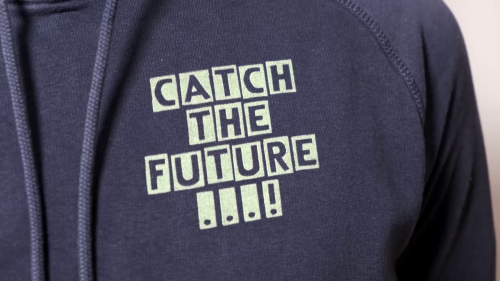 Green lettering Catch the Future printed on a blue sweater