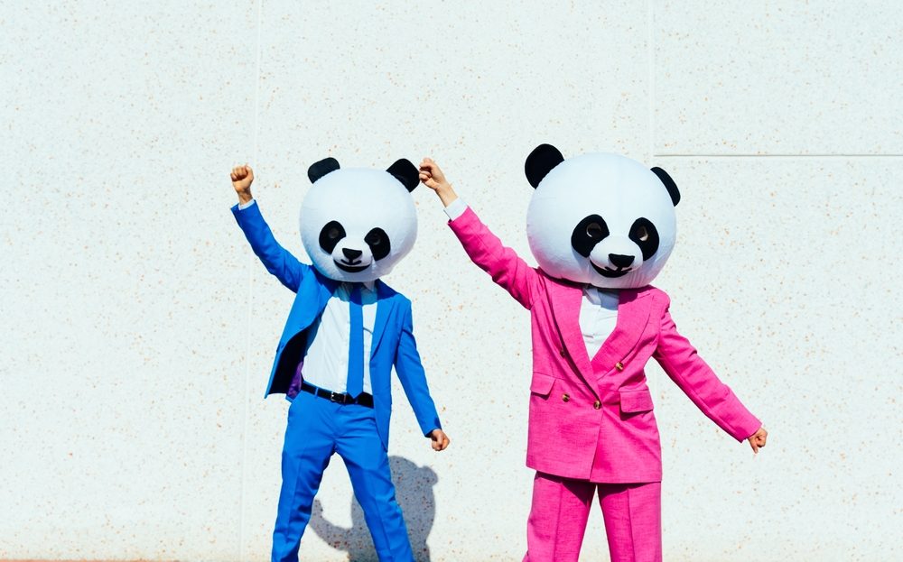Zwei Innovation & Technology Consultants mit Panda Maske tanzen in der Sonne